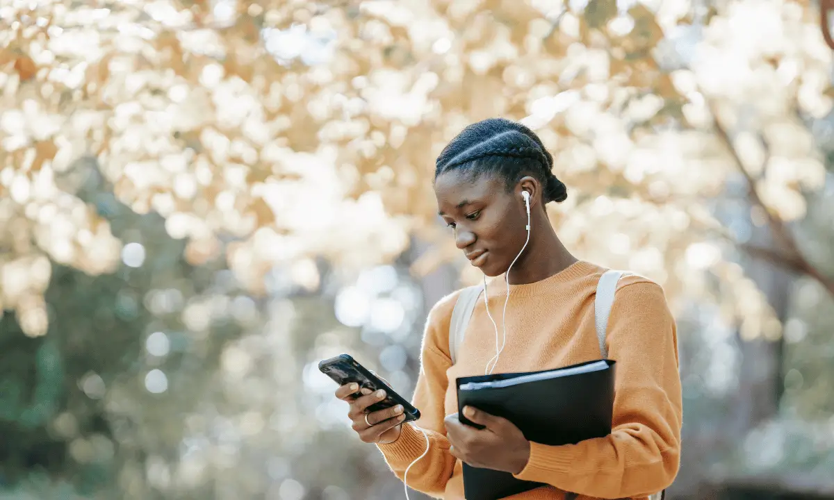 Person using a smartphone for smart home security monitoring in Kenya.
